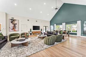 A living room with a dark green accent wall and a ceiling fan.