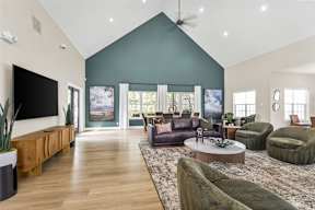 A living room with a green sofa and a wooden floor.