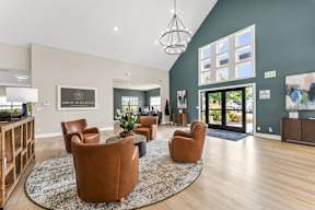 A living room with a rug, chairs, and a painting on the wall.