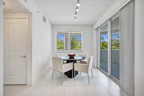 A dining room with a table and chairs.