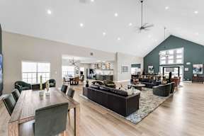 A spacious living room with a long wooden table and multiple seating options.