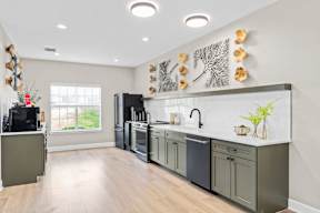 A kitchen with a black fridge and a black dishwasher.
