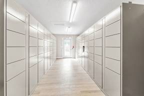 A long hallway with white lockers on both sides.