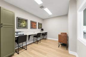 A room with a desk and chairs and pictures on the wall.