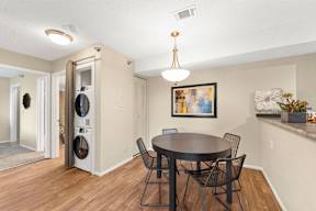 A dining room with a round table and chairs.