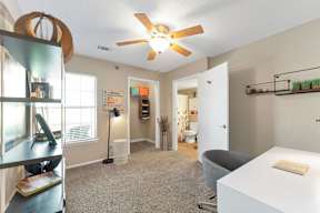 A room with a ceiling fan and a white table with a book on it.