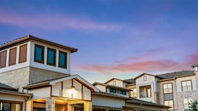 a row of houses with a sunset in the background