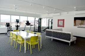 A room with a table, chairs, and a bench.