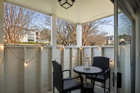 the screened in porch has a table and chairs and lights on it