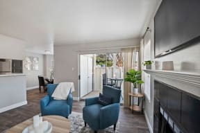 a living room with blue chairs and a fireplace