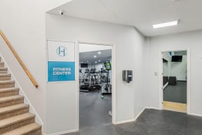 a fitness center with stairs and a door to a gym