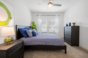 a bedroom with a bed and a dresser and a window