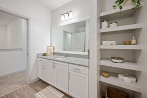 a bathroom with white cabinets and a sink and a mirror