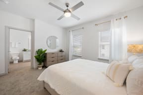 a bedroom with a large bed and a ceiling fan