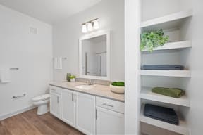 a bathroom with white cabinets and a sink and a mirror