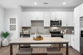 a kitchen with white cabinets and stainless steel appliances
