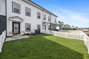 a white house with a yard and a white fence