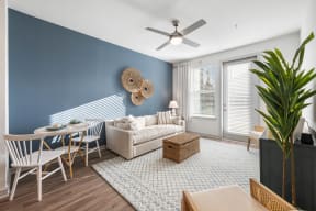 a living room with a couch and a table and a ceiling fan