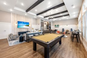 a community room with a pool table and couches