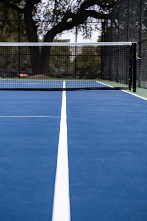 A tennis court with a white line down the middle.