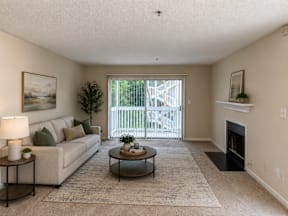 A living room with a couch, coffee table, and fireplace.