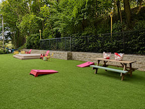 A playground with a green surface and a picnic table.