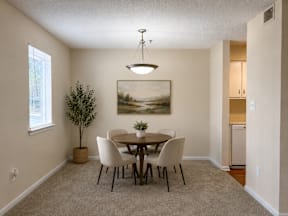 A dining room with a table and chairs.
