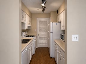 A kitchen with white appliances and cabinets.