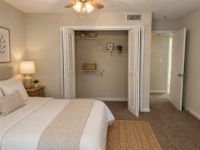 A bedroom with a large bed and a small closet.