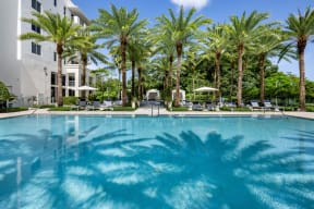 a large pool with palm trees in front of a building