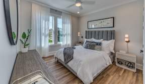 A bedroom with a large bed and a ceiling fan.