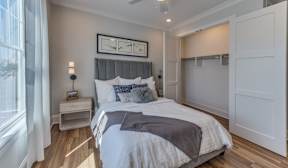 A bedroom with a large bed and a window with curtains.