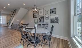 A dining room with a table and chairs.