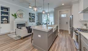 A modern kitchen with a wooden floor and white walls.