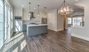 A modern kitchen with a large island and a chandelier.