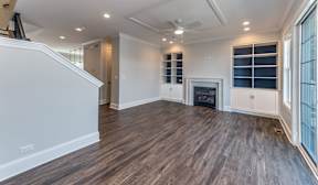 A spacious living room with hardwood floors and a fireplace.