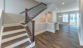 A staircase with wooden steps and a black railing.