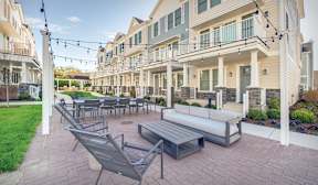 A patio with a table and chairs is surrounded by apartment buildings.
