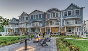 A large, modern house with a patio and outdoor seating area.
