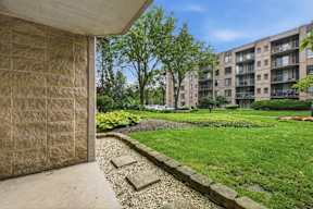 A concrete wall with a stone border and a grassy area in the background.