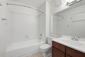 A white bathroom with a toilet, sink, and bathtub.