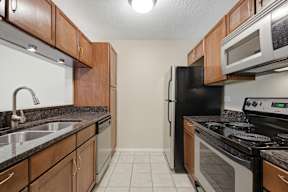A kitchen with black appliances and wooden cabinets.