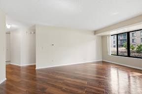 A large empty room with wooden floors and white walls.