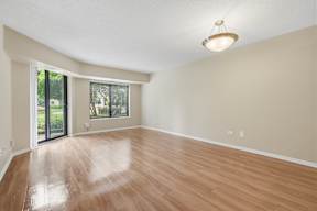 A room with wooden floors and a sliding glass door leading outside.
