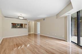 A spacious room with wooden flooring and a flat screen TV mounted on the wall.