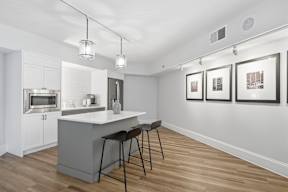 A kitchen with a bar stool and a counter.