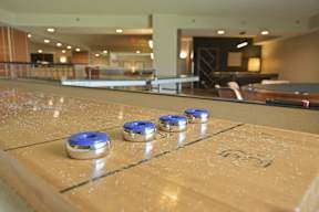A shiny pool table with blue and silver coins on it.