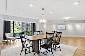 A dining room with a wooden table and chairs.