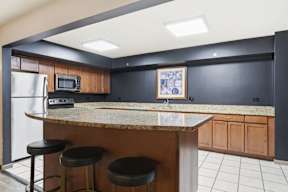 A kitchen with a bar counter and stools.