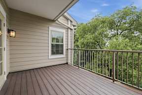 A wooden deck with a railing and a window.